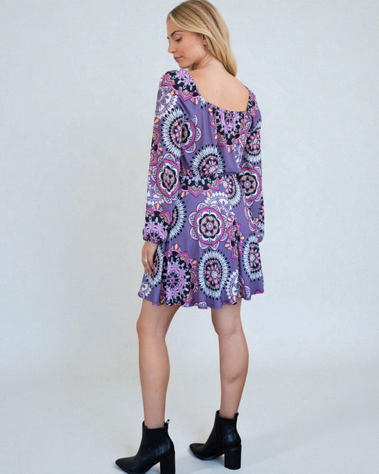 Woman wearing a purple patterned dress on a white background
