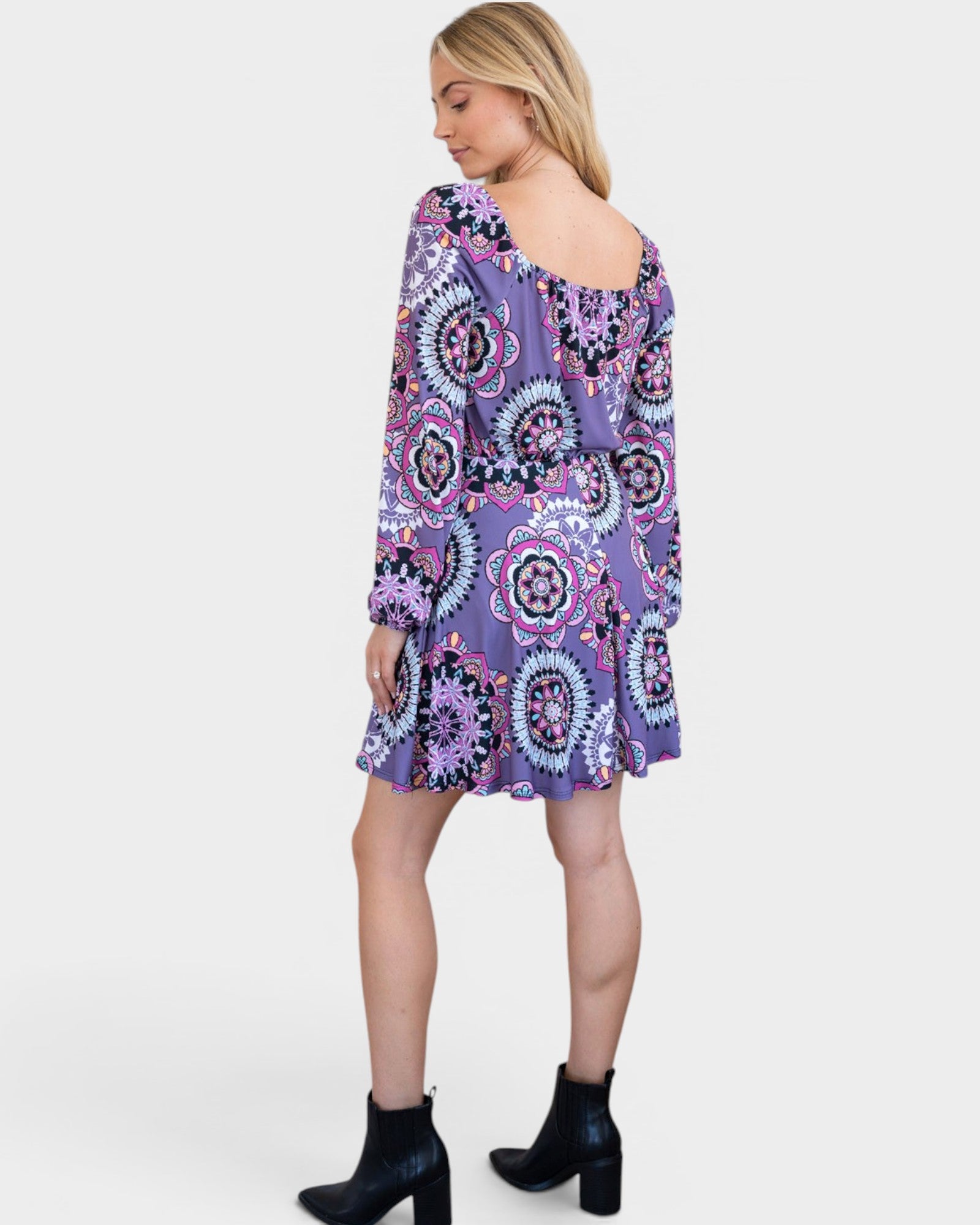 Woman wearing a purple patterned dress on a white background