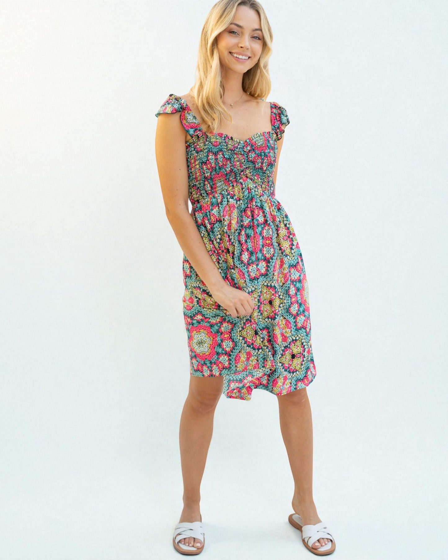 Woman wearing a colorful floral dress on a white background