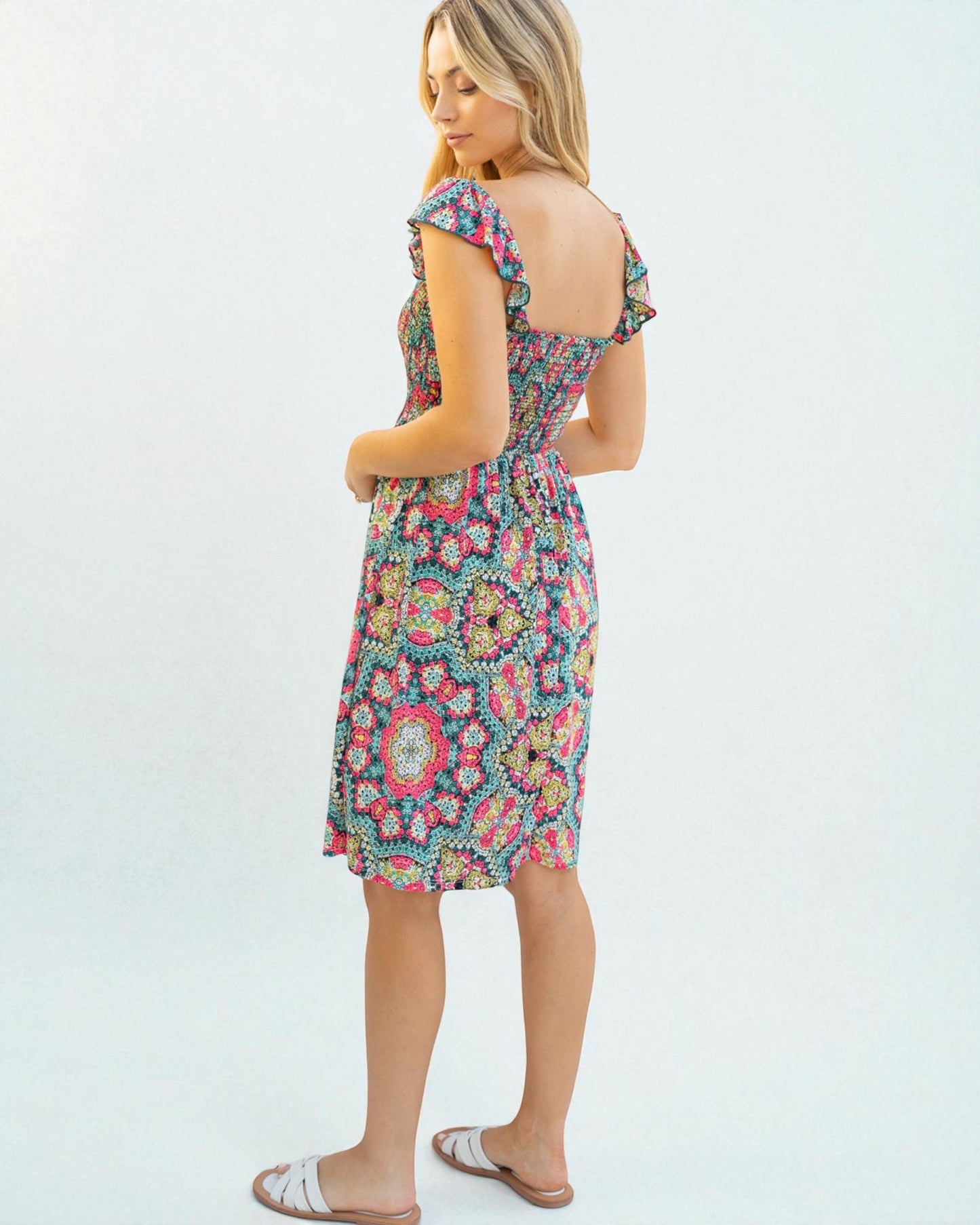 Woman wearing a colorful floral dress on a white background