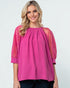 Woman wearing a pink blouse with sheer sleeves on a white background