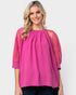 Woman wearing a pink blouse with sheer sleeves on a white background