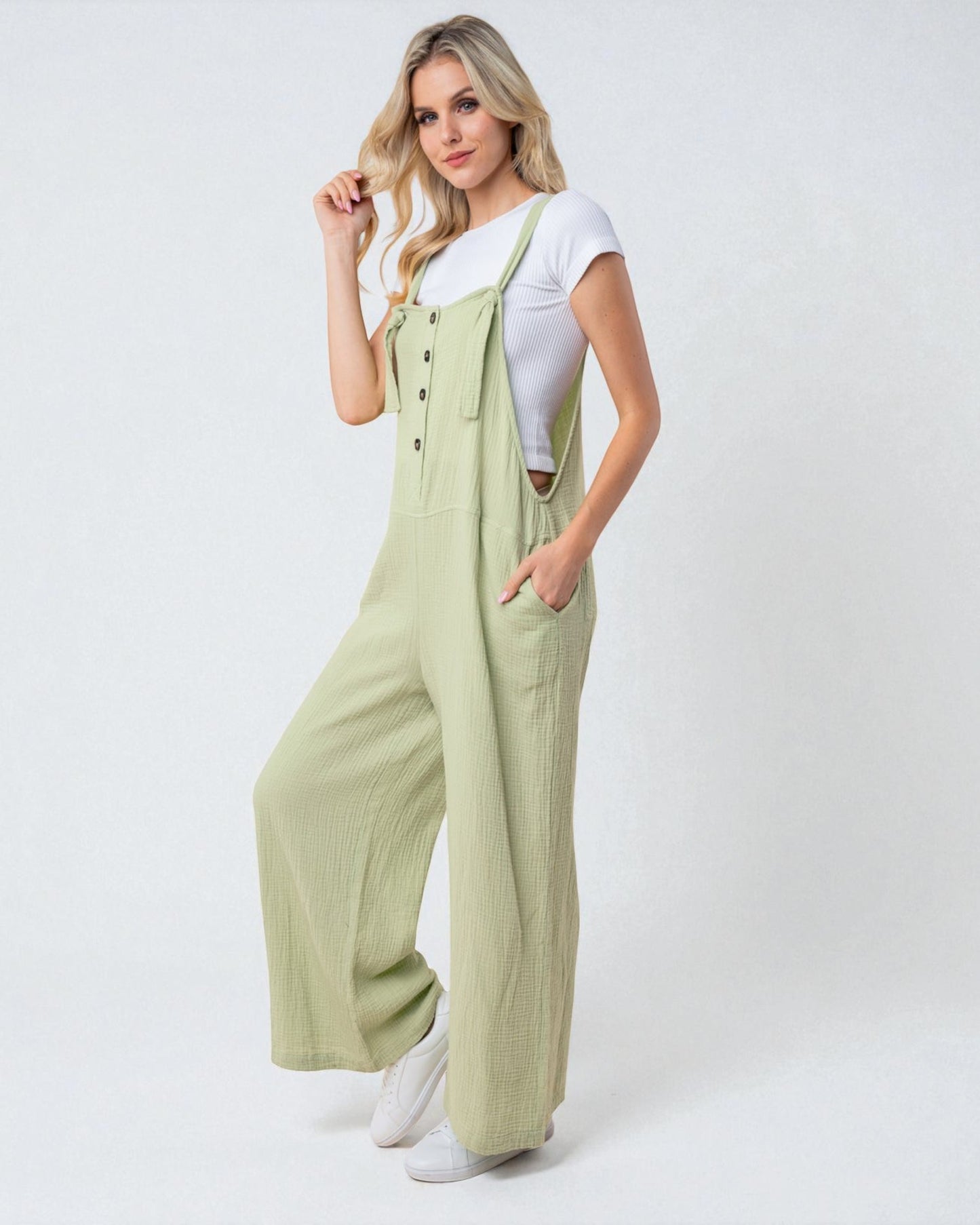 Woman wearing a light green jumpsuit on a white background