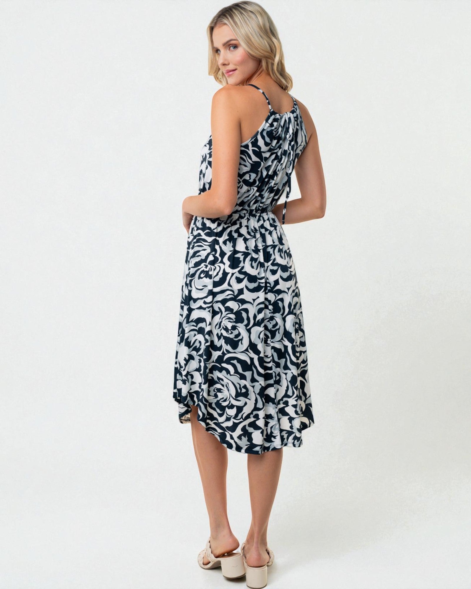 Woman wearing a black and white patterned dress on a white background