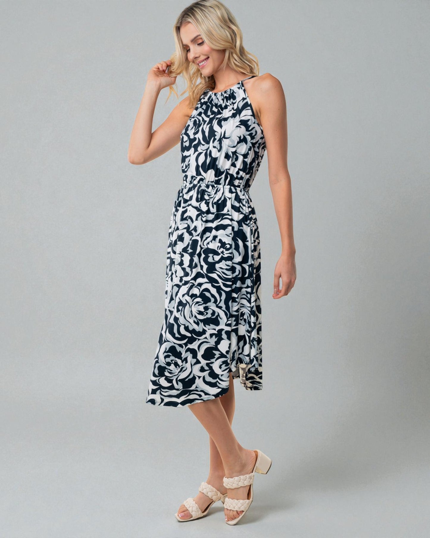 Woman wearing a black and white patterned dress on a gray background