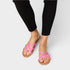Person wearing pink sandals on a plain background