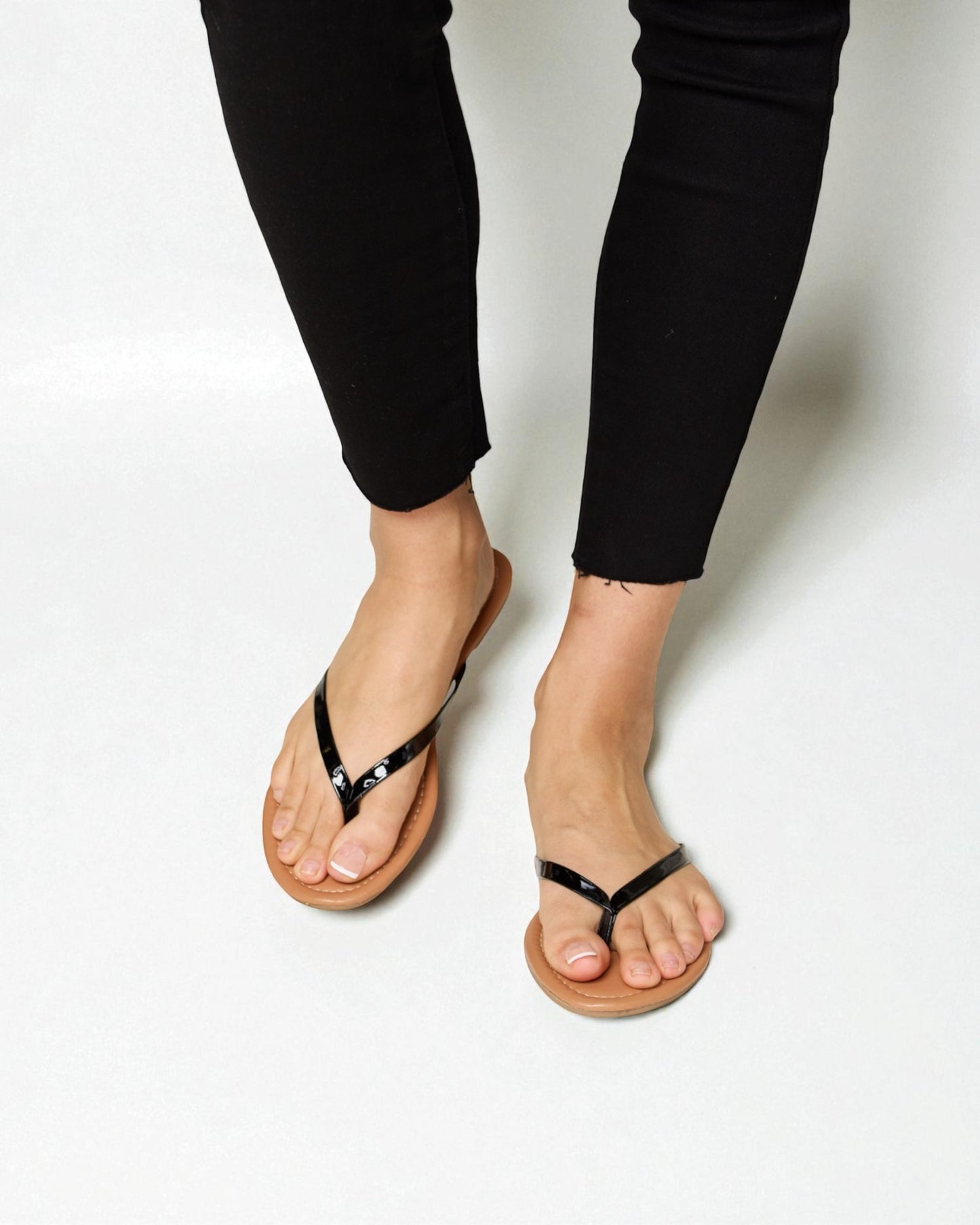 Person wearing black sandals on a white background