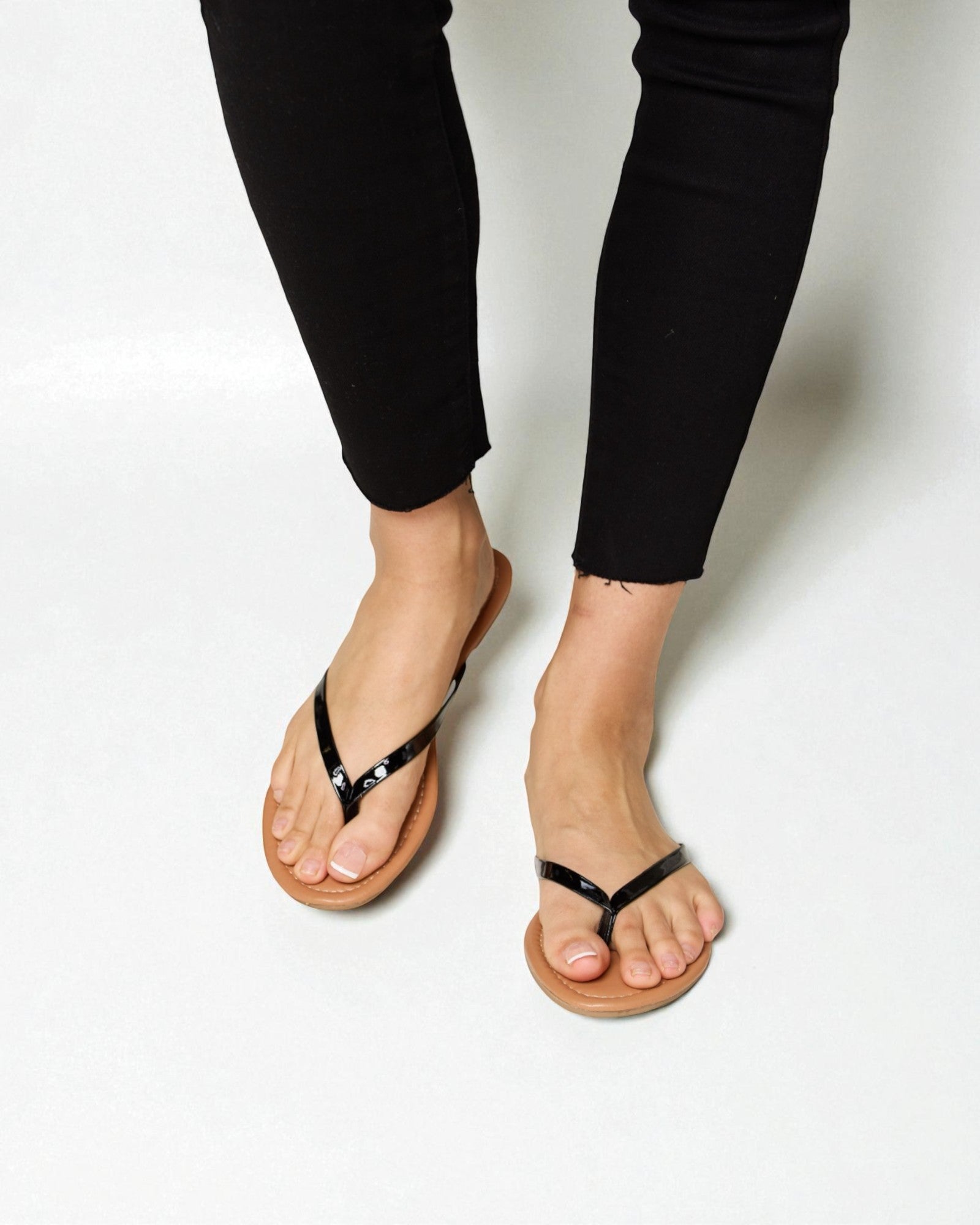 Person wearing black sandals on a white background