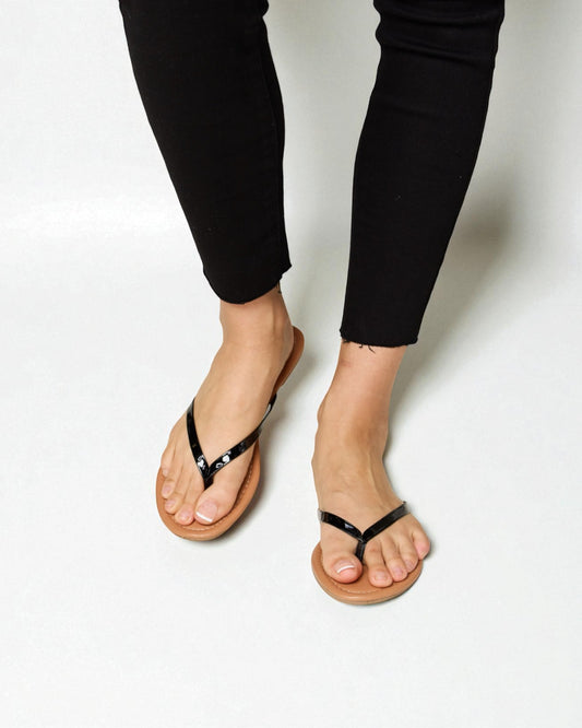 Person wearing black sandals on a white background