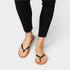 Person wearing black sandals on a plain background