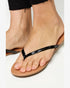 Beige sandals with black straps worn by a person on a white background