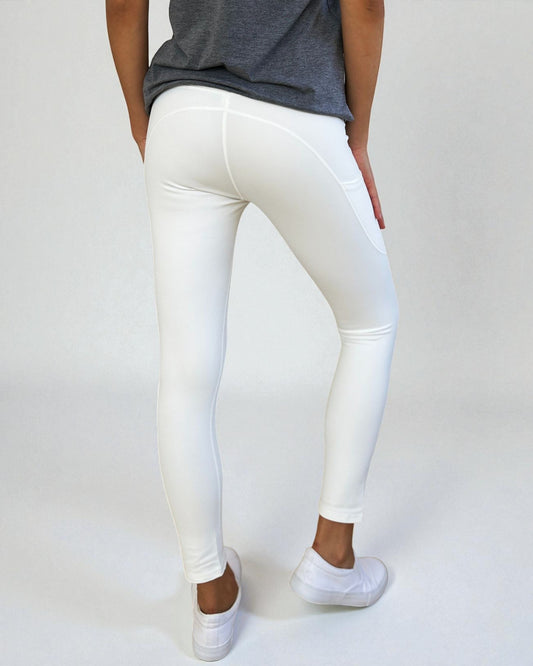 Person wearing white leggings and a gray top on a plain background