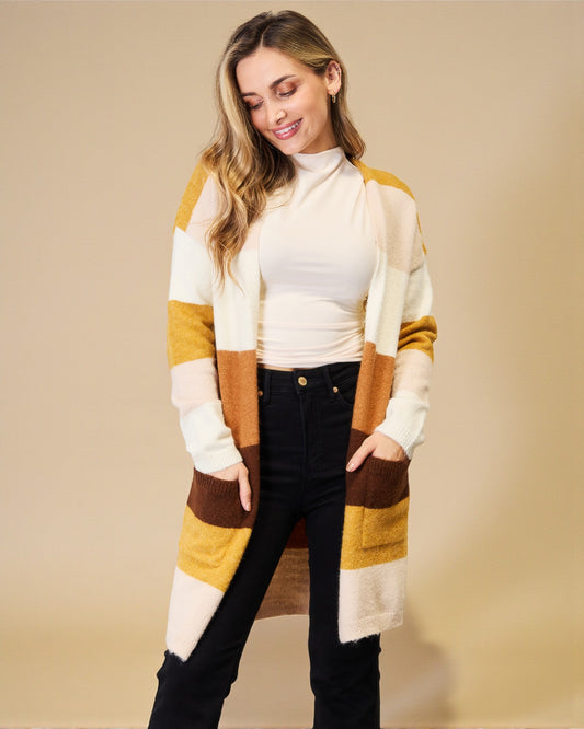 Woman wearing a striped cardigan over a white turtleneck on a beige background