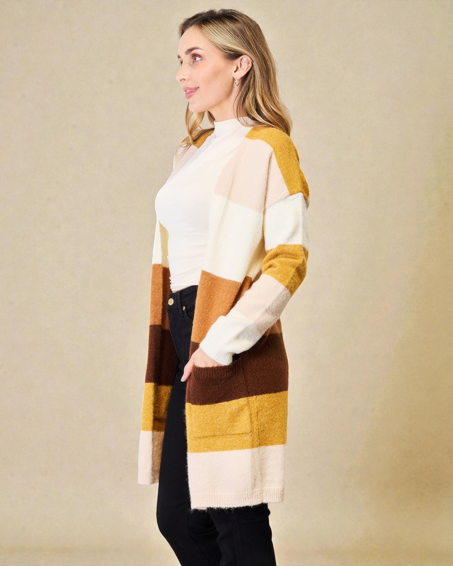 Woman wearing a colorful striped cardigan against a beige background