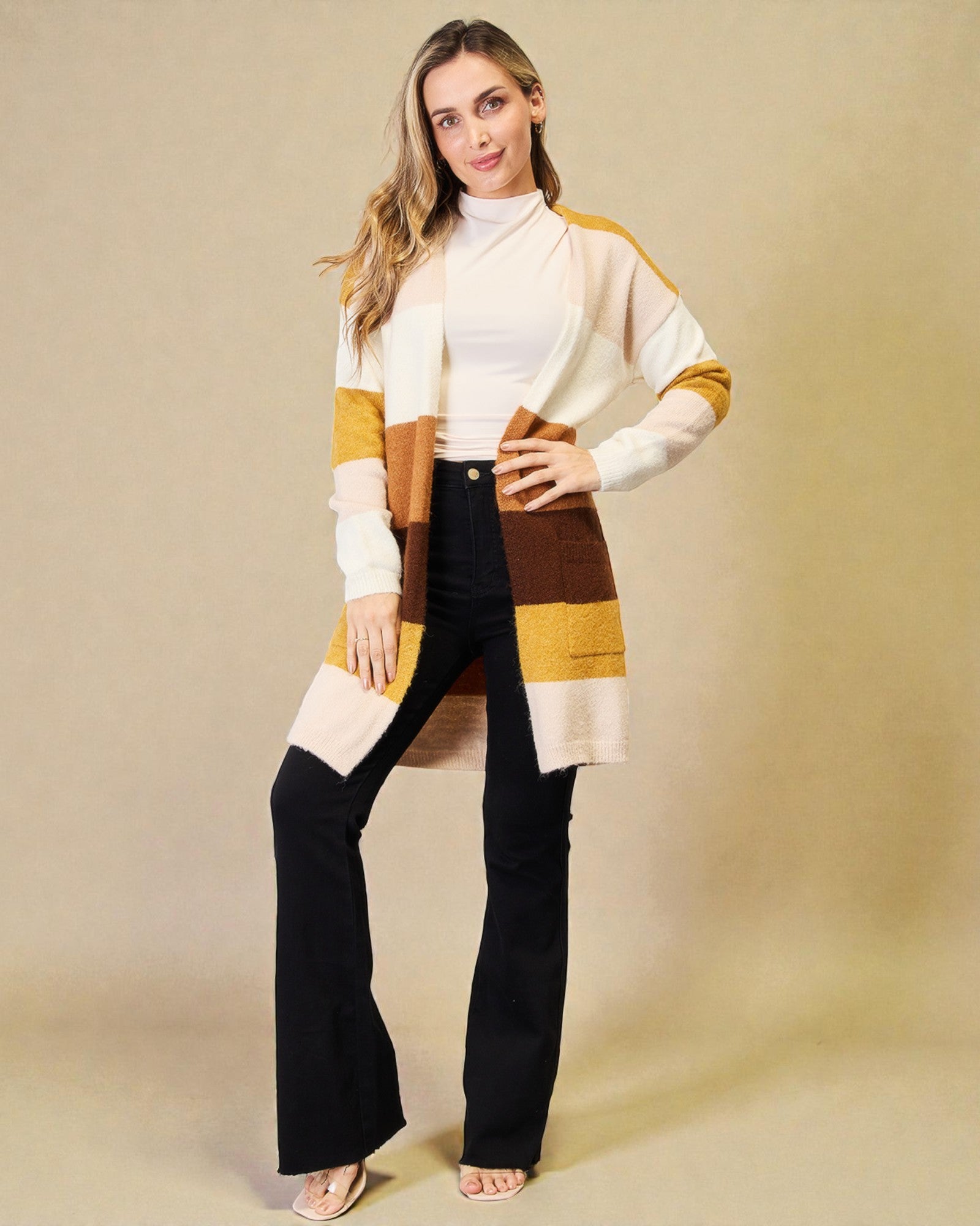 Woman wearing a colorful cardigan over a black dress on a beige background