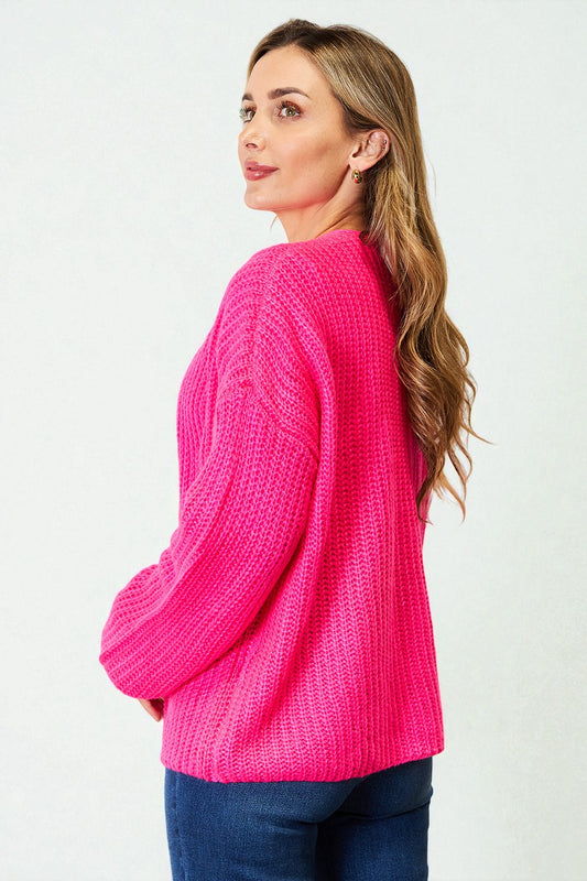 Woman wearing a bright pink sweater against a white background