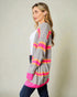 Woman wearing a gray cardigan with pink and orange stripes on a plain background