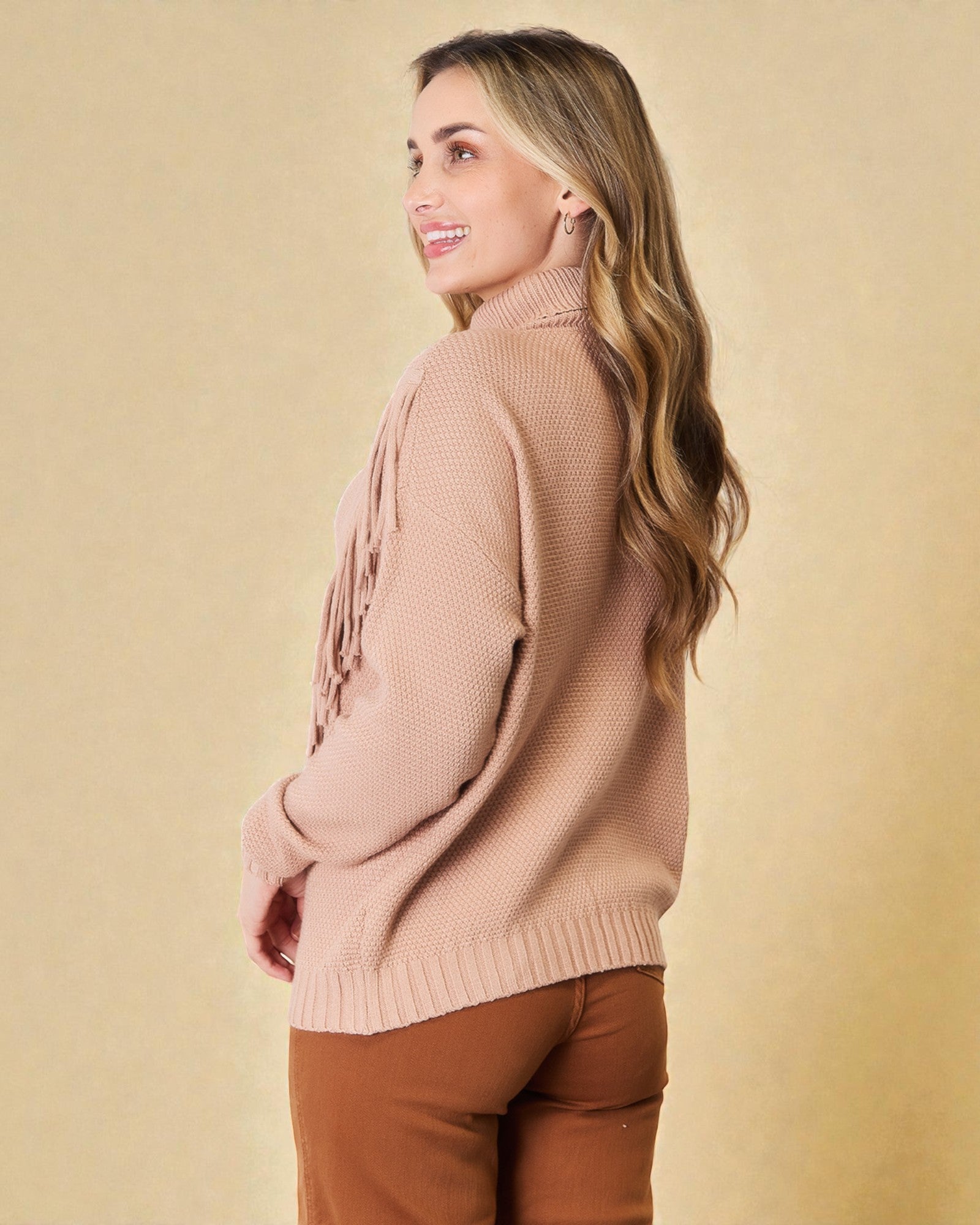Woman wearing a pink sweater against a beige background