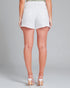 Person wearing white denim shorts on a plain background