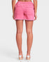 Person wearing pink shorts on a white background