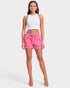 Woman wearing a white tank top and pink shorts on a white background