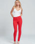 Woman wearing a white top and red pants on a gray background
