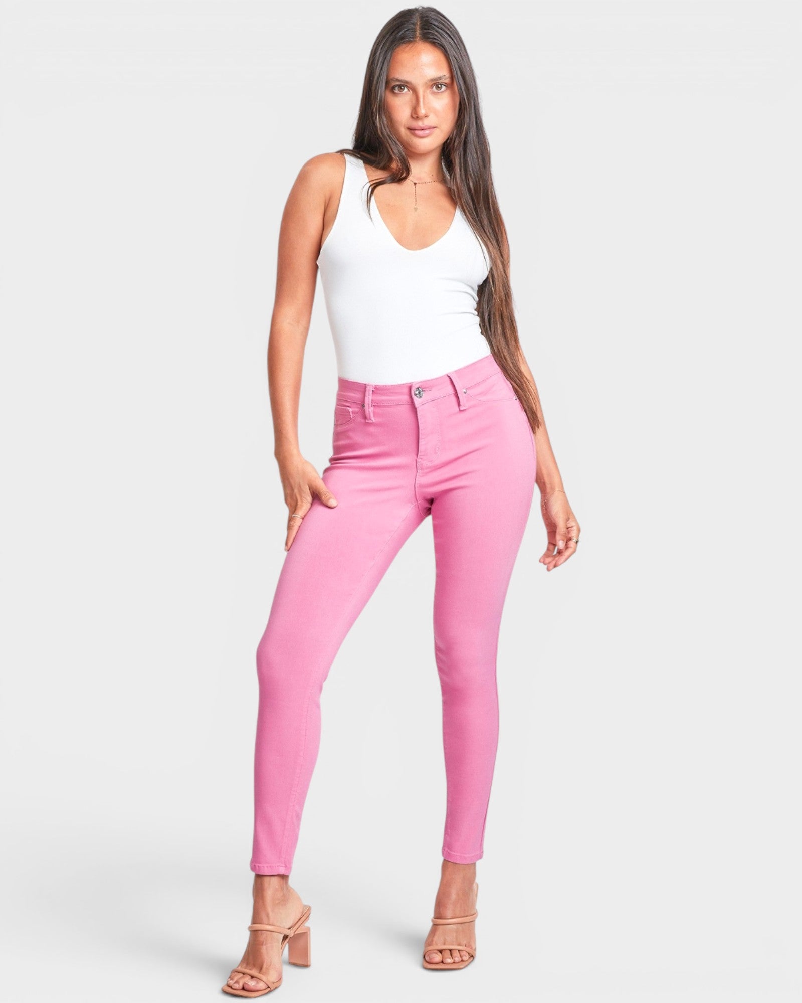 Woman wearing pink pants and a white top on a white background