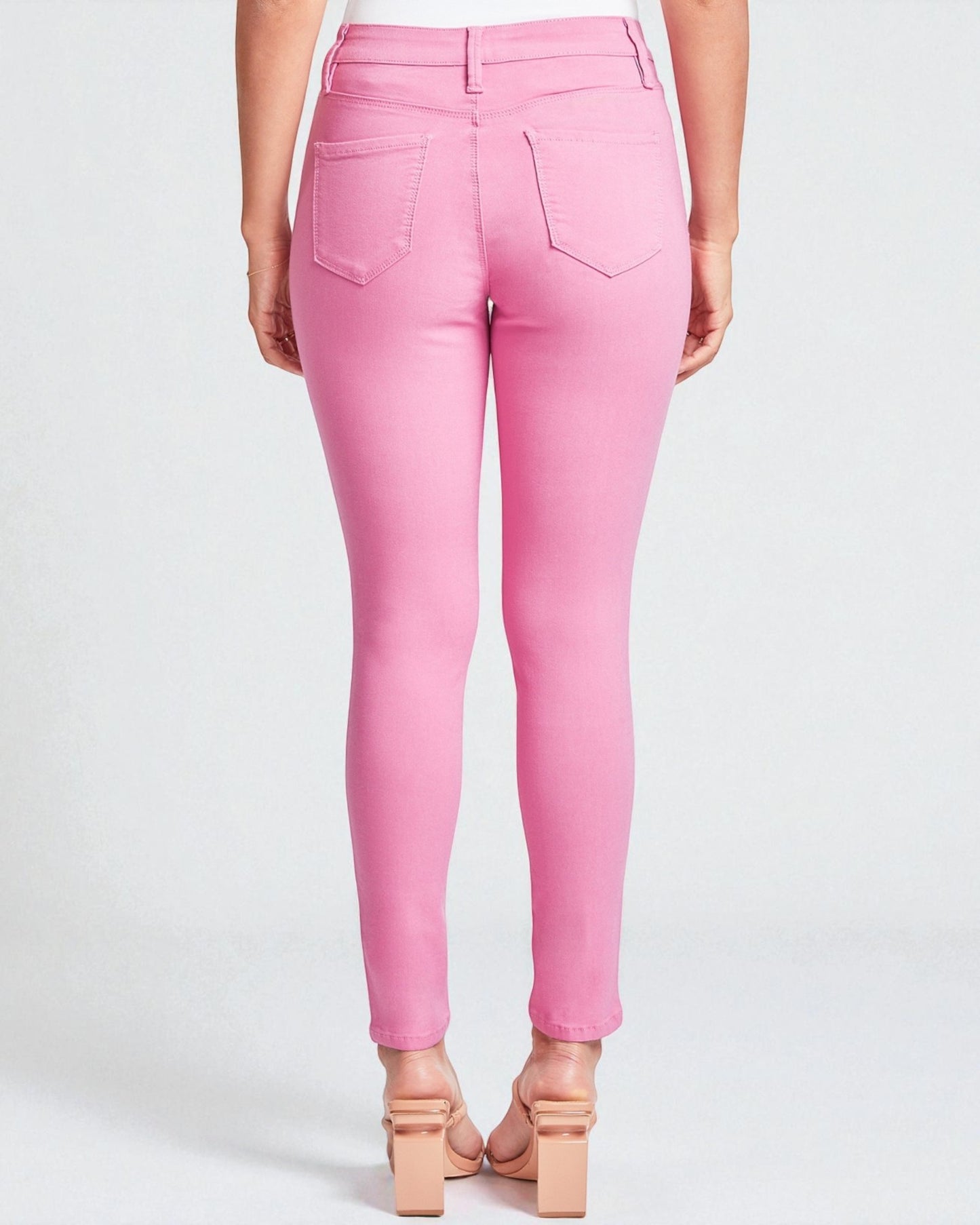 Pink jeans worn by a person on a white background