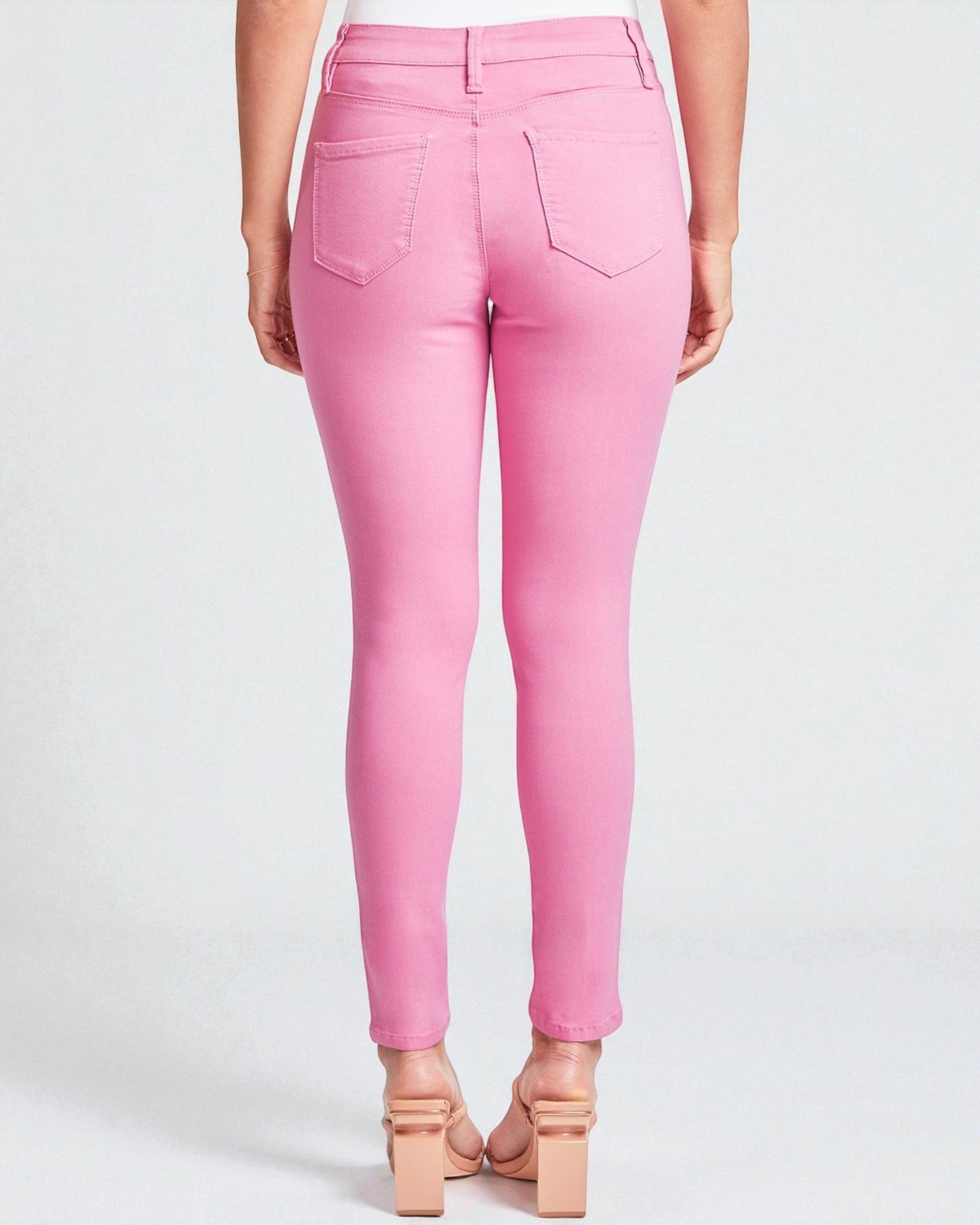 Pink jeans worn by a person on a white background