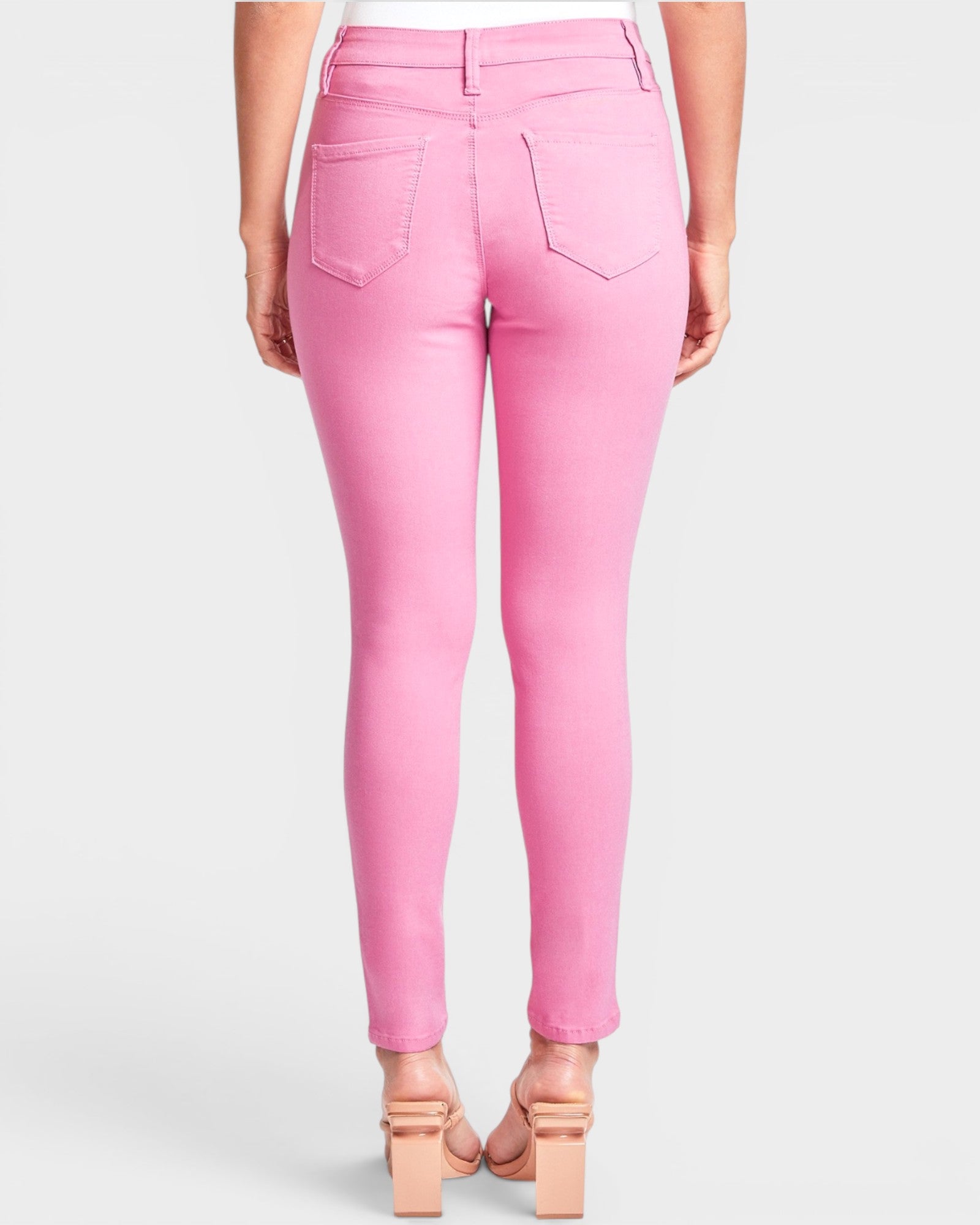 Pink jeans worn by a person on a white background