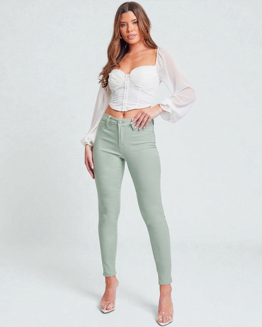 Woman wearing a white top and light green pants on a white background