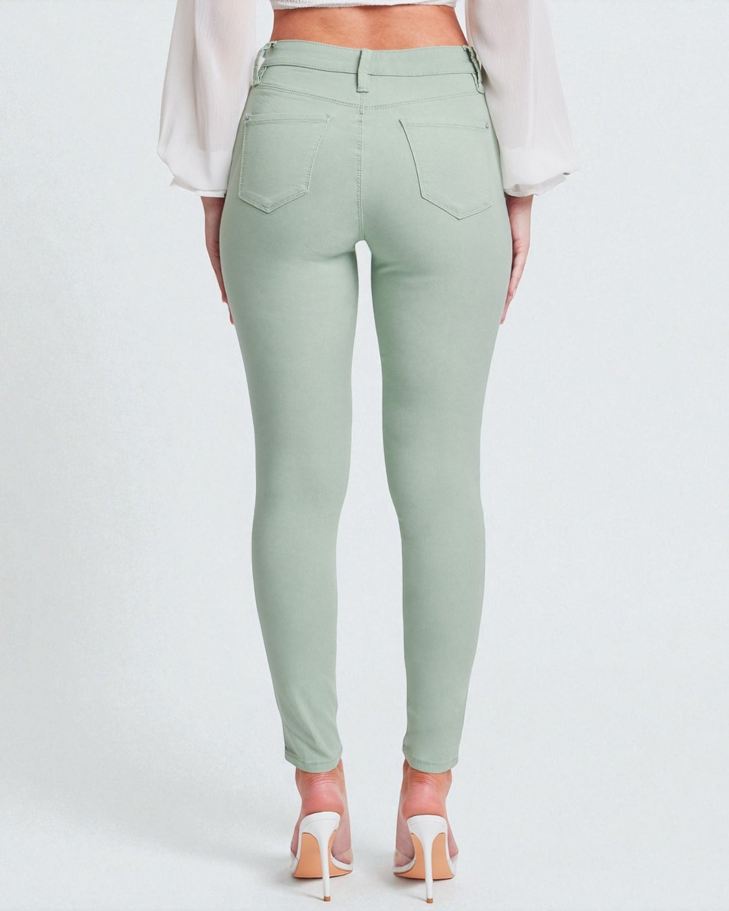 Mint green pants worn by a person on a white background