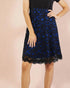 Blue lace skirt worn by a person on a pink background