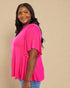 Woman wearing a bright pink top against a beige background