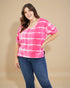 Woman wearing a pink and white striped shirt and blue jeans on a beige background