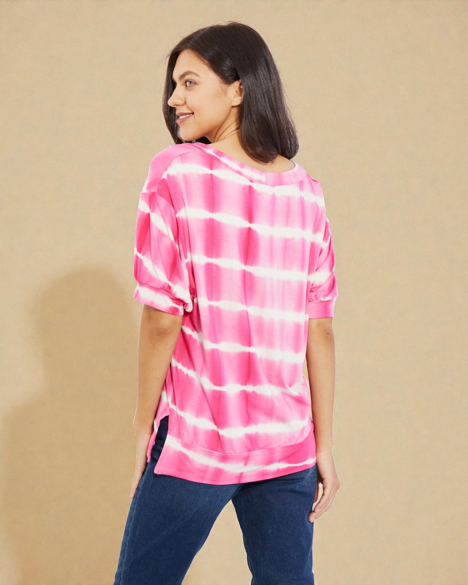 Woman wearing a pink and white striped shirt against a beige background