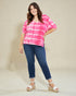 Woman wearing a pink and white tie-dye shirt with blue jeans on a beige background