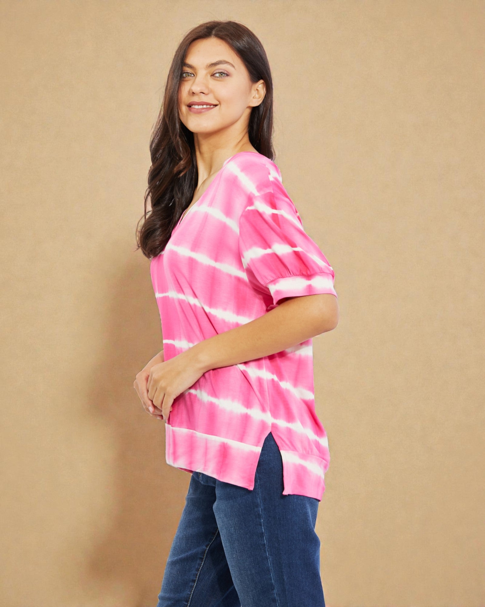 Woman wearing a pink tie-dye shirt against a beige background
