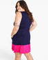 A woman modeling a sleeveless bodycon mini dress with a dark navy blue upper section and a bright hot pink ruffled hem, shown from a three-quarters back view against a plain white studio background.