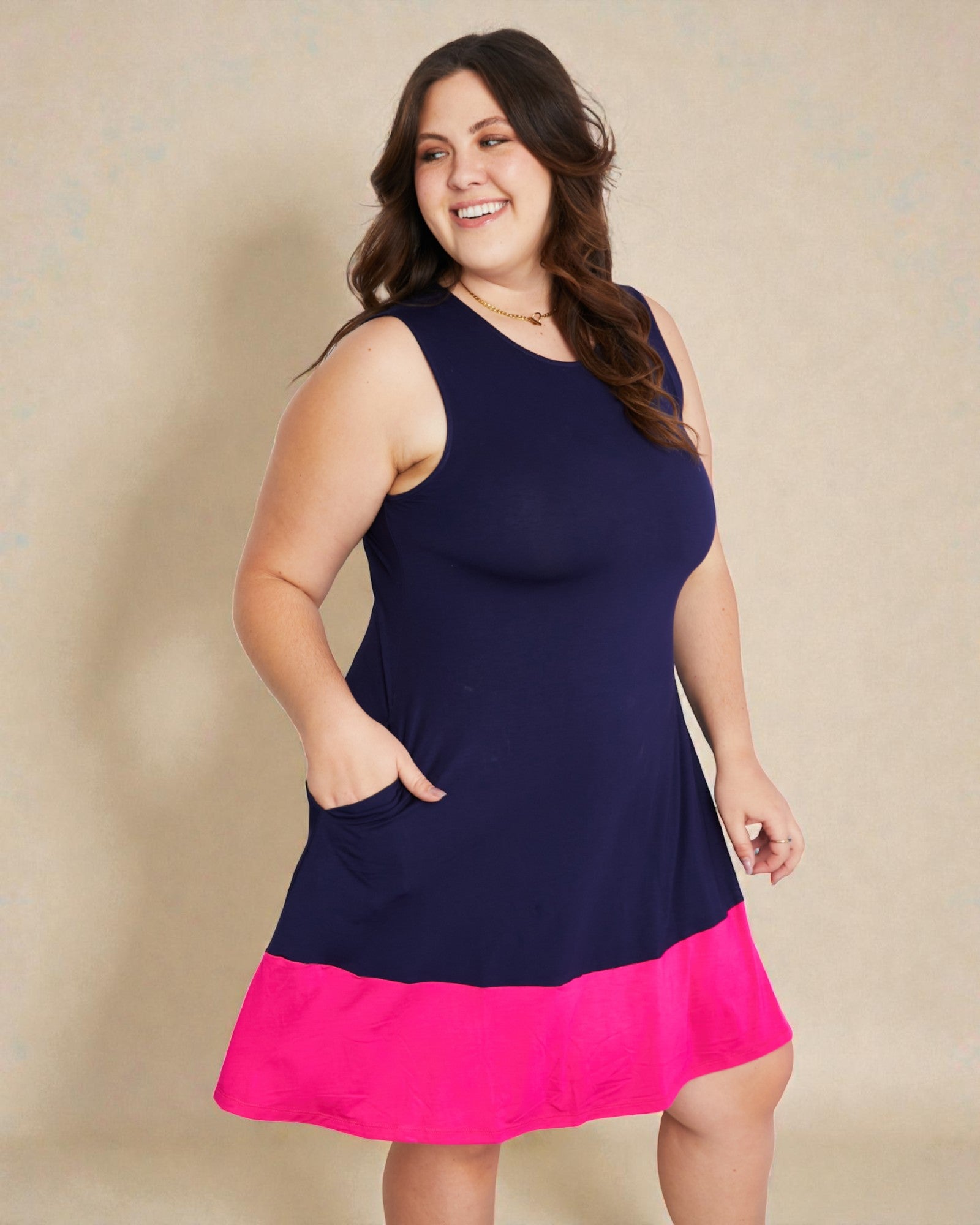 Woman wearing a navy and pink dress against a beige background
