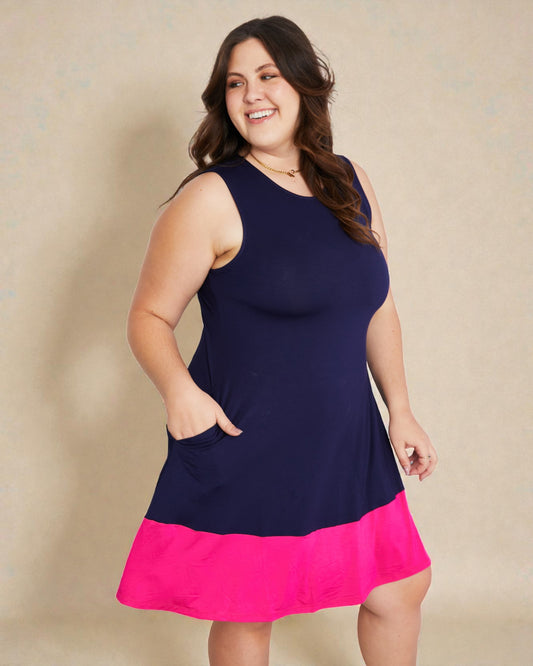 Woman wearing a navy and pink dress against a beige background
