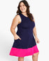 A woman modeling a sleeveless colorblock dress with a navy blue upper section and a bright pink flared hem, set against a plain light gray studio background.