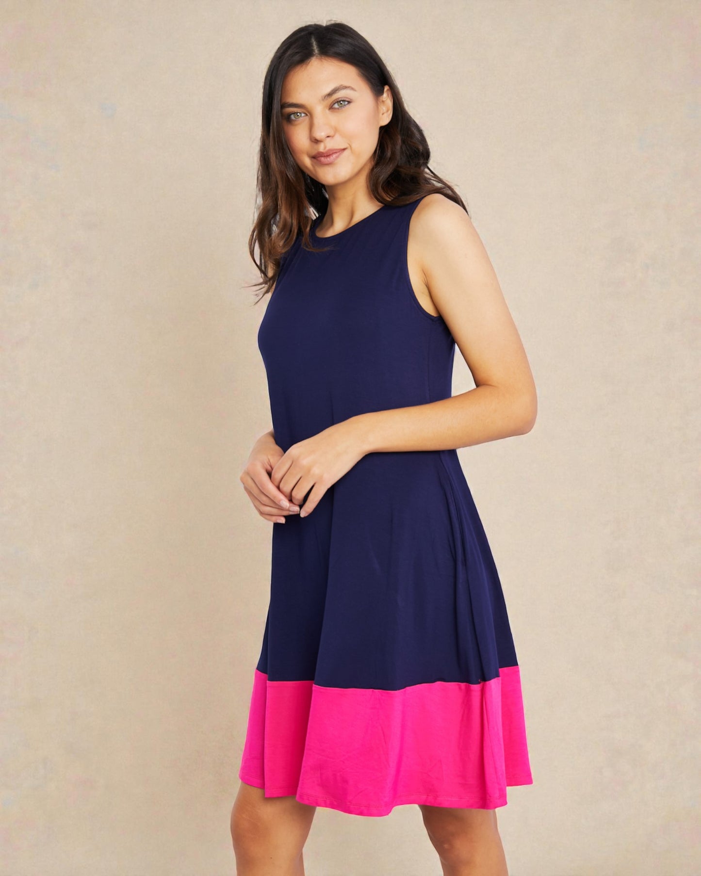 Woman wearing a navy and pink dress against a beige background