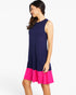 A woman modeling a sleeveless colorblock dress with a navy blue upper body and a bright pink flared hem, photographed against a clean white background.