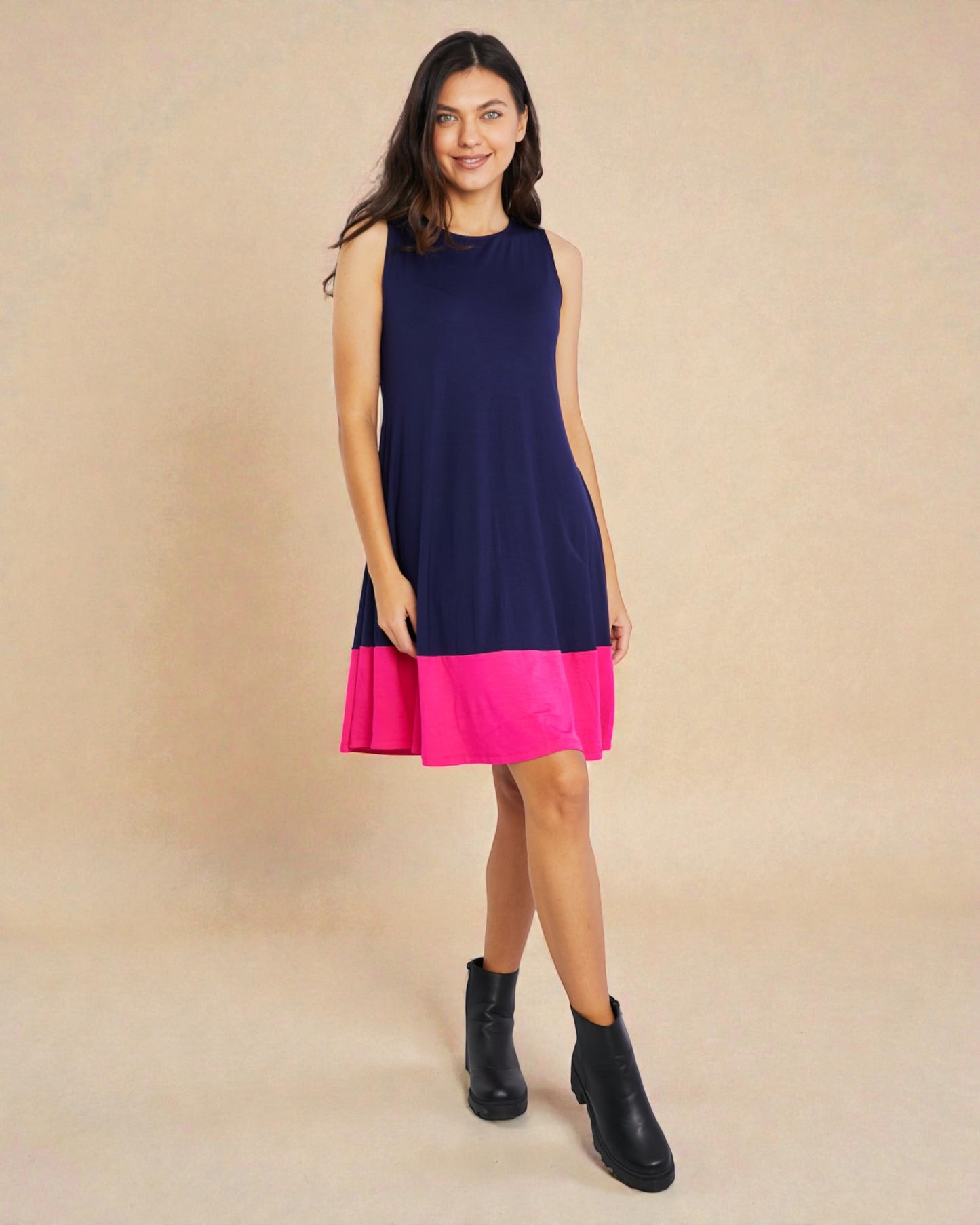 Woman wearing a navy and pink dress on a beige background