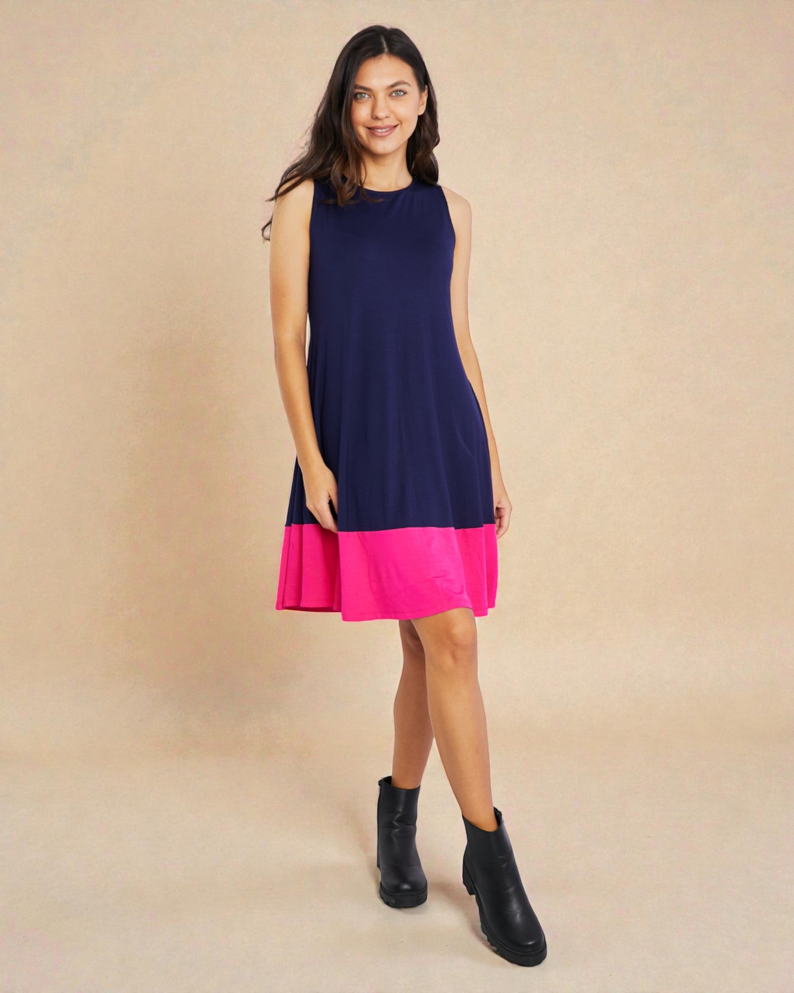 Woman wearing a navy and pink dress on a beige background