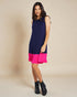 Woman wearing a navy and pink dress on a beige background