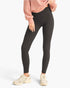 A model wearing high-waisted black leggings, a dusty pink sweatshirt, and beige sneakers, shown from the waist down against a light gray studio background.