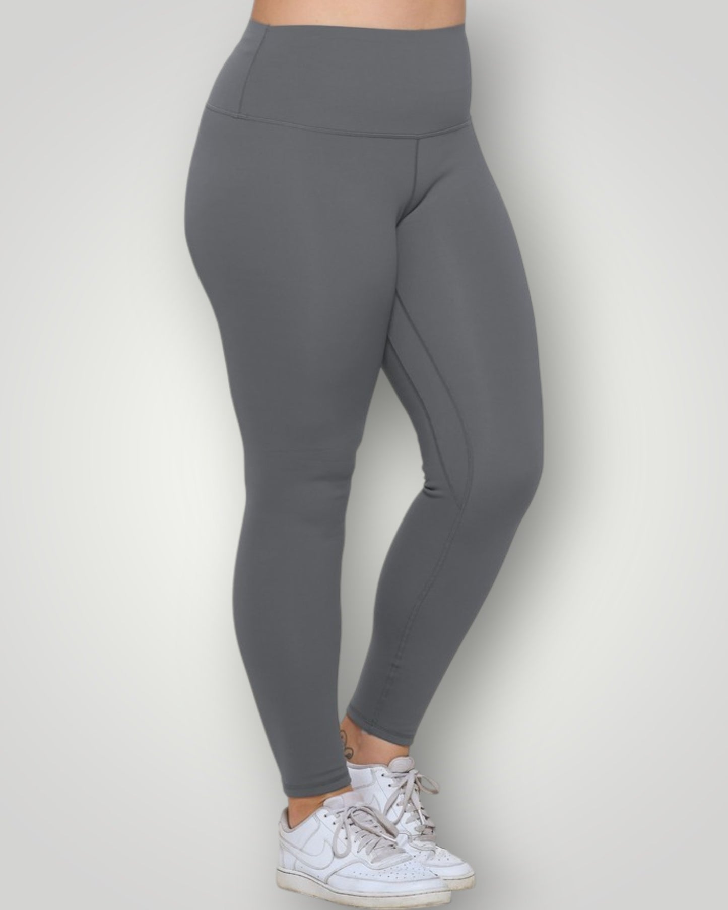 Gray leggings worn by a person on a white background