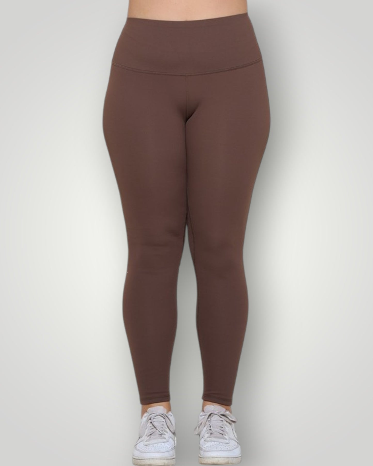 Brown leggings worn by a person on a white background